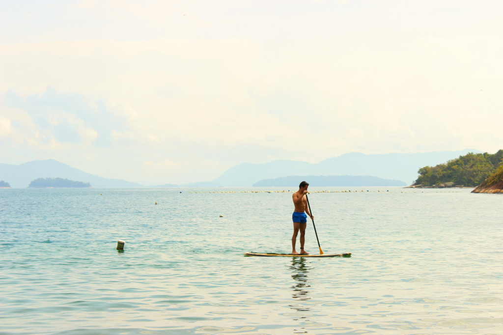 Woman paddle boarding on the beach, Photo By Pedro Sucupira